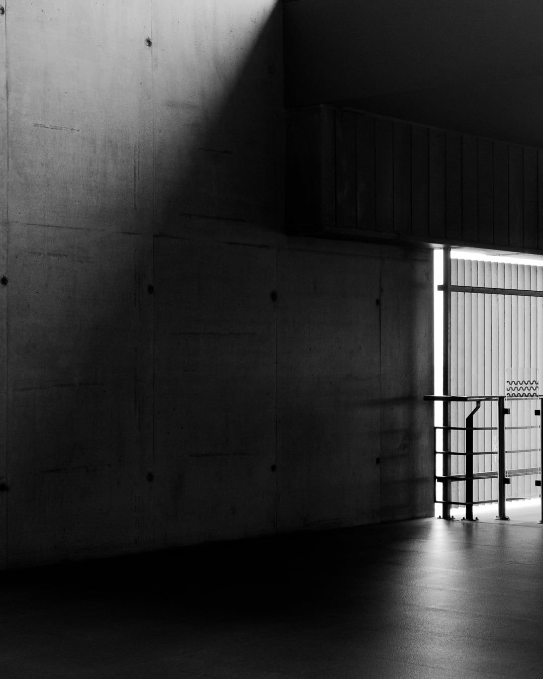 A concrete corridor with a slab of light