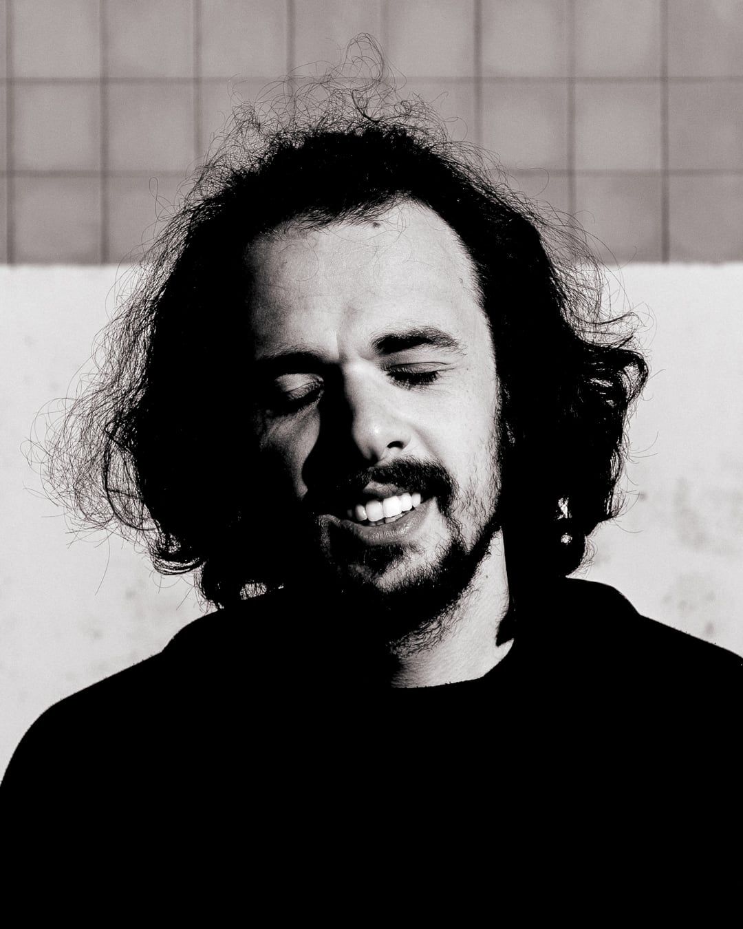 A curly-haired man smiling