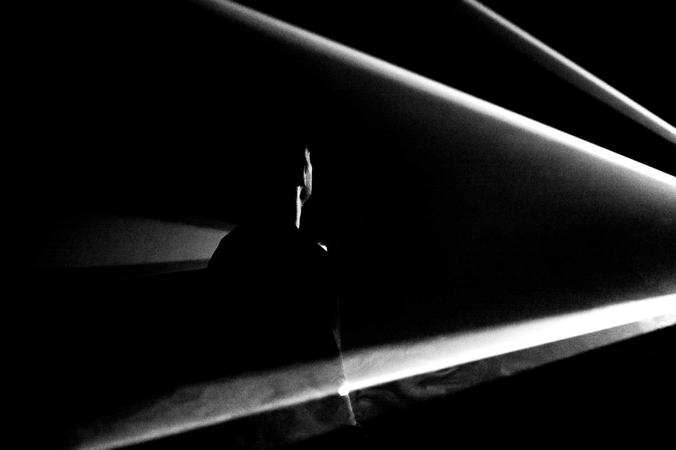 A figure standing in beams of light