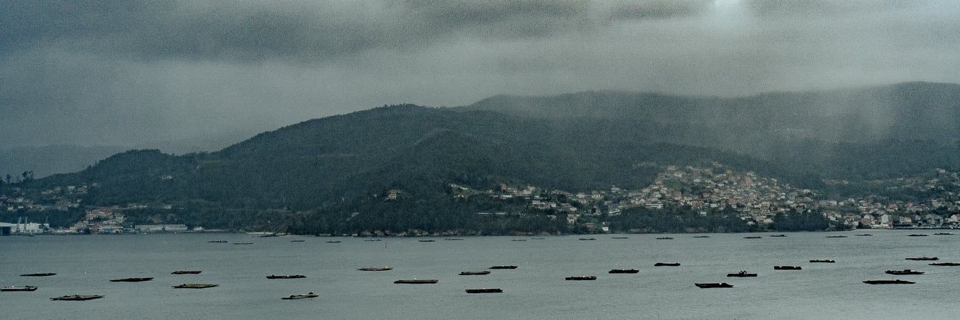 A rainy bay below hills