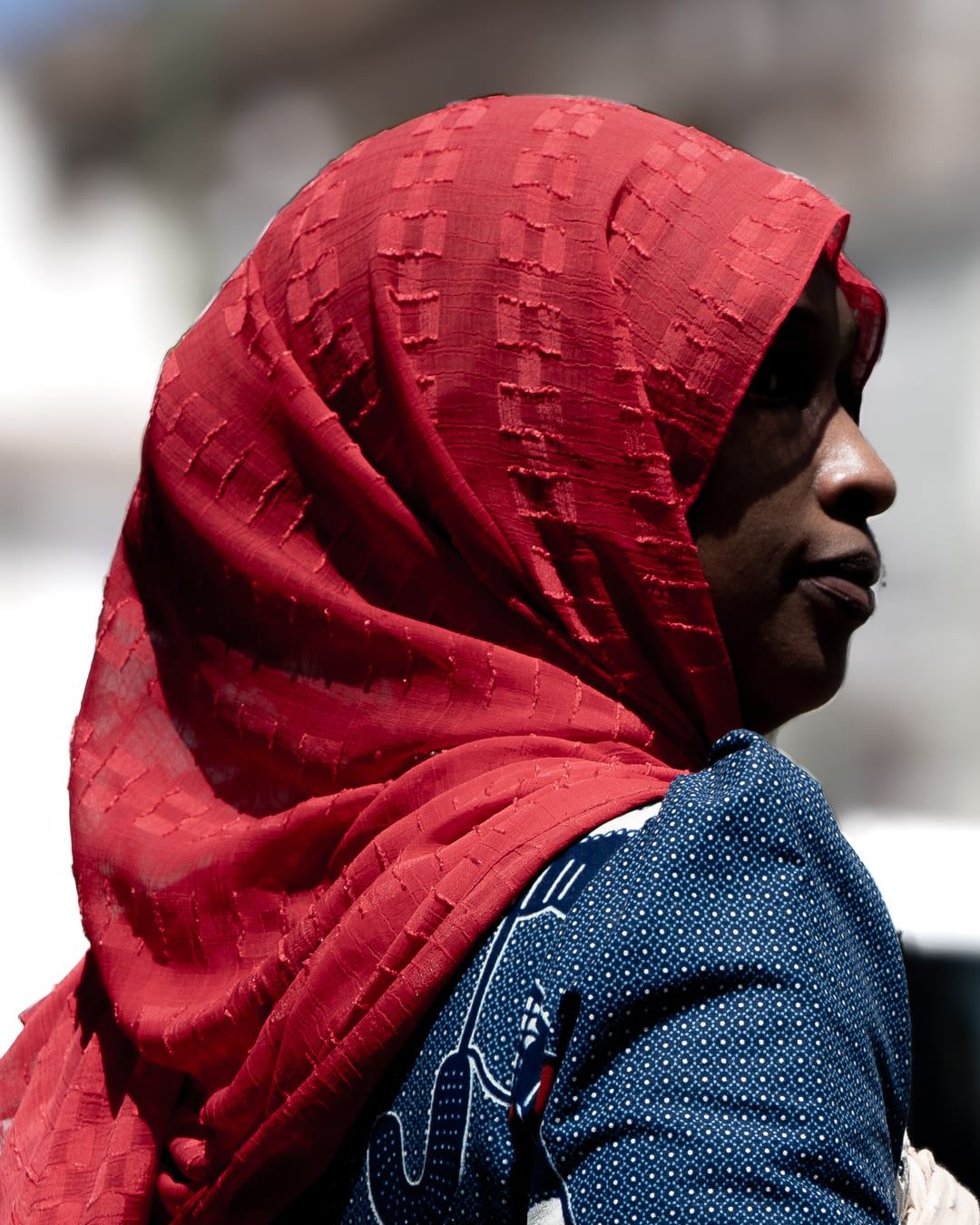 A woman in a red headscarf